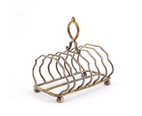 A Victorian Silver Toast rack, by Edward Hutton, London, 1891, oblong and with seven bars and an overhead loop handle, on fou