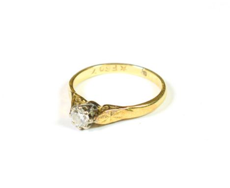 A diamond solitaire ring, the round brilliant cut diamond in a white claw setting, to a yellow tapered shoulder plain polishe