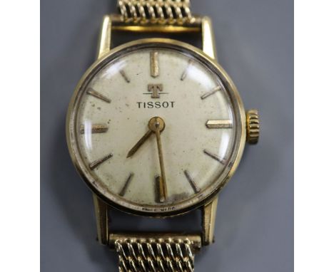 A 750 yellow metal Tissot manual wind wrist watch, on a 585 yellow metal bracelet.