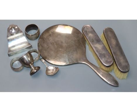 A George III silver caddy spoon, pair of silver clothes brushes and hand mirror, ink well, egg cup, 3 napkin rings.