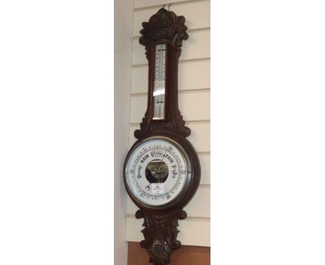 An Edwardian carved oak wheel barometer, by Scargill H.83cm