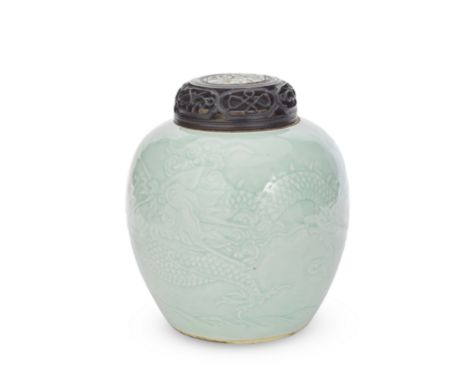 A CARVED CELADON-GLAZED 'DRAGON' JARQing DynastyOf globular form carved to depict a four-clawed dragon flying among clouds an