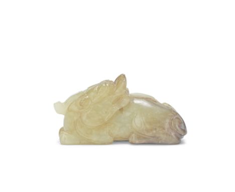 A CREAMY RUSSET JADE CARVING OF A RECUMBENT CHILONGMing DynastyThe recumbent beast modelled with its head turned to the rear 
