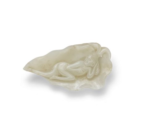A PALE CELADON JADE 'MEDICINE DOLL' PLAQUE19th centuryThe lotus leaf-shaped plaque enclosing a reclining naked lady  resting 