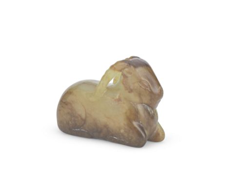A YELLOW AND RUSSET JADE CARVING OF A RECUMBENT RAMMing DynastyCarved with the legs neatly tucked beneath the body, the ribbe