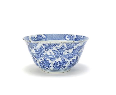 A MOULDED BLUE AND WHITE ARMORIAL BOWLKangxiDecorated to the exterior with floral sprays and insects panels, inside the flare