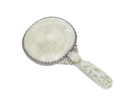 A PALE CELADON JADE BELT HOOK AND OVAL PLAQUE MOUNTED AS A MIRROR18th/19th centuryThe large oval plaque incised to depict two
