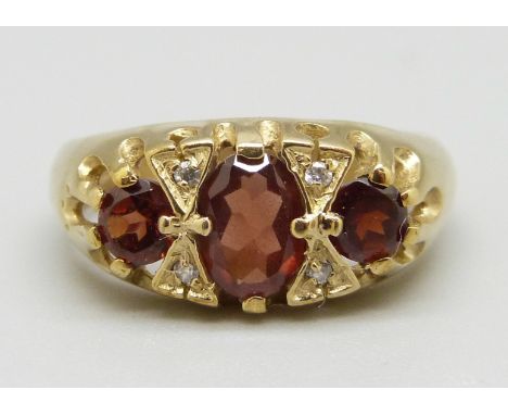 A 9ct gold ring set with garnets and white stones, 3.3g, M 