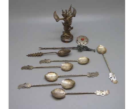 Six spoons marked 800, one other spoon with pagoda detail, a fork with giraffe finial, a model of a dancer and a brooch 