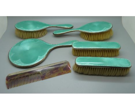 A silver and enamel dressing table set, mirror, four brushes and a comb 
