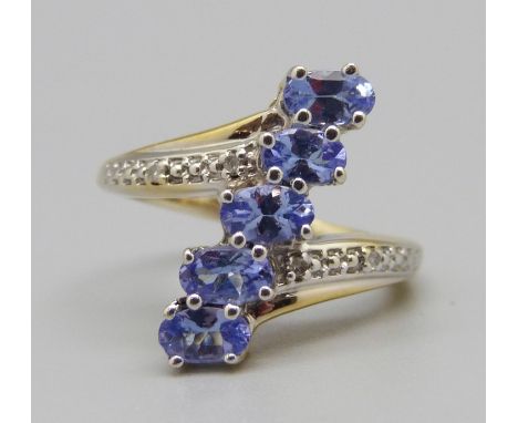 A silver gilt, five stone tanzanite ring with diamond accents, L 