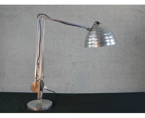 A brushed steel electric desk top angle poise style lamp, on circular foot. H.67 W.58cm 