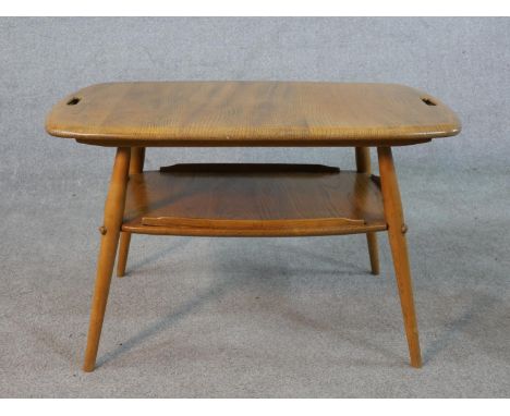 A 20th century blonde elm and beech Ercol two tier occasional tray table, model number 457, raised on four splayed supports. 