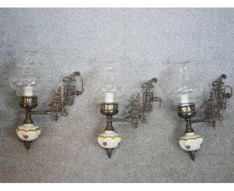 A set of three Edwardian cast metal wall lights, the ornate branches with hare decoration, with painted ceramic bodies and en