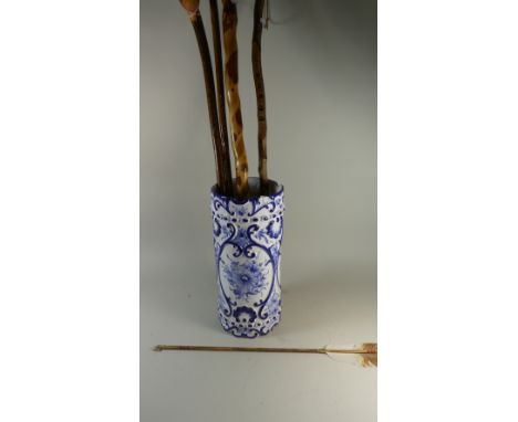 A Ceramic Blue and White Stick Stand Containing Walking Sticks, Staffs and American Indian Arrow