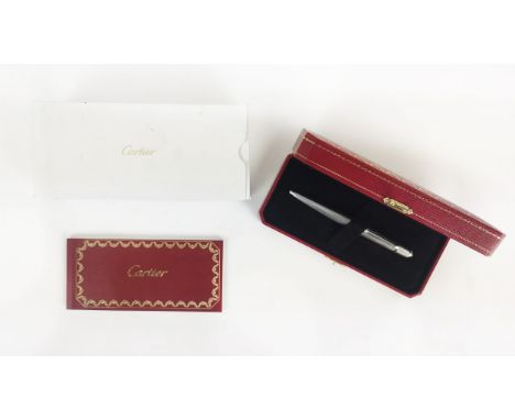 A CARTIER WHITE METAL BALLPOINT PEN, engine turned decoration, blue resin cabouchon to end, complete with box and paperwork