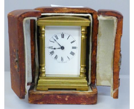 A small brass and four glass sided carriage clock with French movement, inscription to case top in a fitted travel case 
