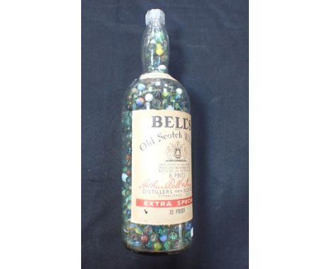AN 8-PINT BELL'S WHISKY BOTTLE FULL OF GLASS MARBLESand a few larger marbles in a bag
