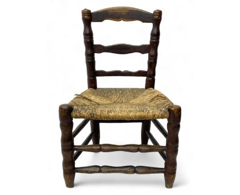 19th century painted elm primitive fire side chair, ladder back over rush seat, on turned supports united by turned stretcher