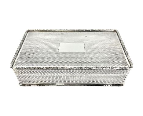 1920's silver table cigarette box, of rectangular form with engine turned decoration to the exterior, the hinged cover with c