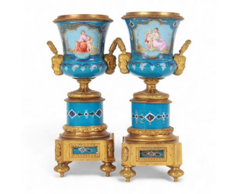 Pair of 19th century Sevres style gilt bronze mounted urns, each porcelain urn with twin gilt bronze mask ring handles, paint