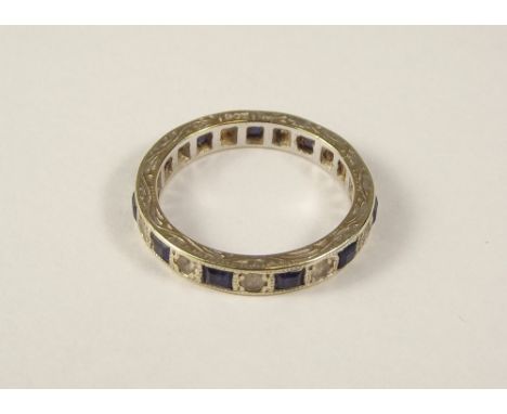 ETERNITY RING. A 9ct. gold eternity ring set with blue &amp; white stones.