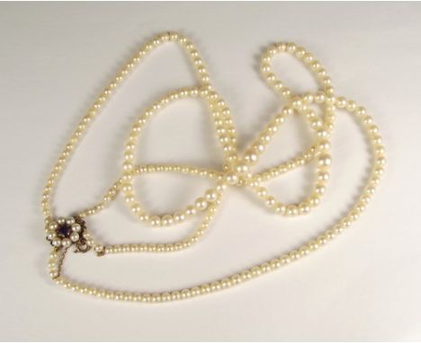 CULTURED PEARLS. A double strand of Lotus cultured pearls with 9ct. gold amethyst &amp; pearl clasp. Original case &amp; leaf