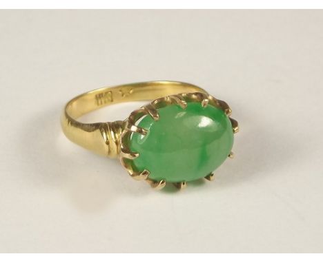 JADE RING. A yellow metal ring, set an oval green jade stone. 1.2 x 1cm. Stamped WS &amp; one other indistinct numeral.