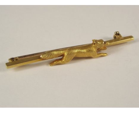 STOCK PIN. A yellow metal stock pin, cast a running fox with a ruby eye.