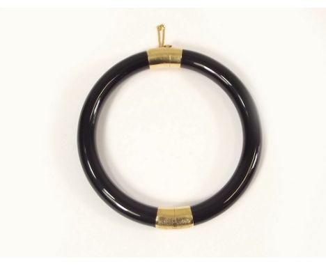 BANGLE. A 14k. gold mounted, hinged black jade or onyx bangle. (purchased Hong Kong)