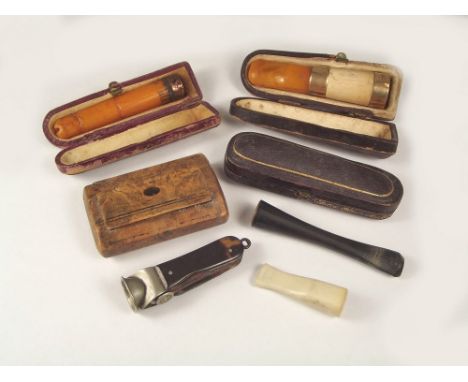 CIGARETTE HOLDERS ETC.
Three amber cigarette/cigar holders, a burrwood snuff box, a cigar cutter etc.