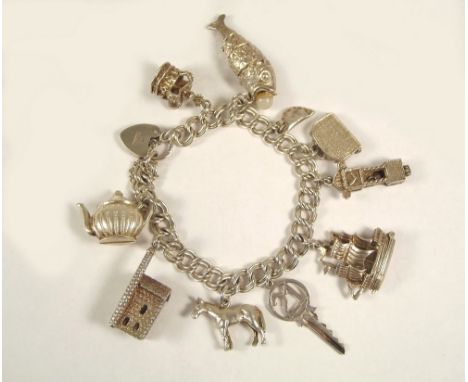 CHARM BRACELET. A silver charm bracelet, hung a mine engine house, a Cornish pasty etc.