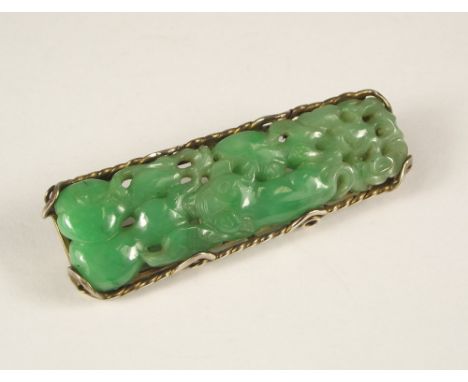 JADE BROOCH. A Chinese carved jade brooch, in yellow metal mount. 1.7 x 5.5cm irregular.