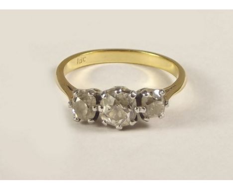 DIAMOND RING. An 18ct. gold three stone diamond ring. Size K/L.