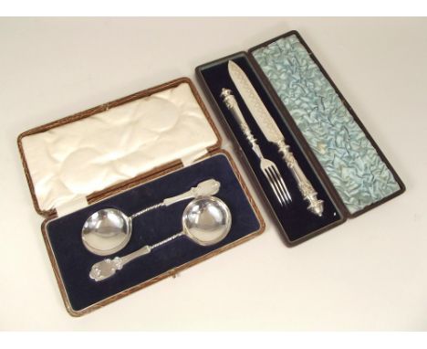 CASED SETS. A Victorian plated bread knife &amp; fork &amp; a pair of fruit spoons.