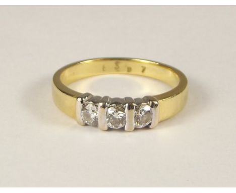 DIAMOND RING. An 18ct. gold three stone diamond ring. Size M/N.