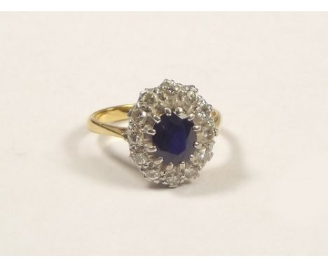 SAPPHIRE RING. An 18ct. gold sapphire &amp; diamond cluster ring. Size Q/R. Setting size 1.5 x 1.3cm.