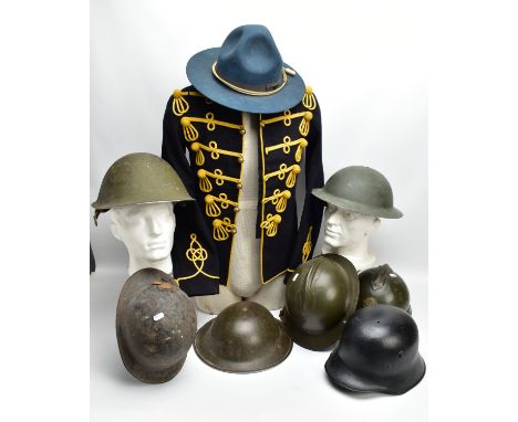 A BOX CONTAINING EIGHT PIECES OF MILITARY HEADWEAR, to include three French Adrianne style metal helmets one being a WWI reli