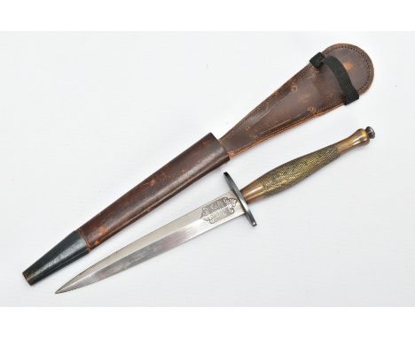 A FAIRBAIRN-SYKES FIGHTING KNIFE, complete with leather scabbard, this example is believed to be a Mk 2 variety, with turned 