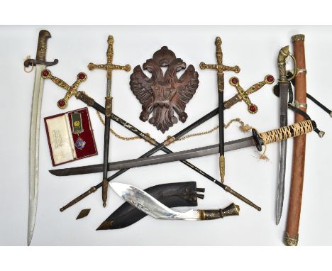 A WOODEN MADE HERALDIC SHIELD, made to display two swords and daggers in a cross design, possibly European, all items present