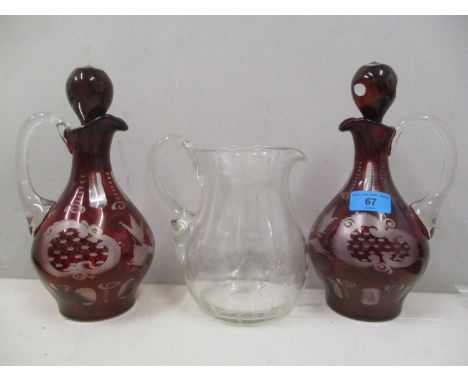 A pair of Bohemian style ruby glass wine jugs, together with a water jug 