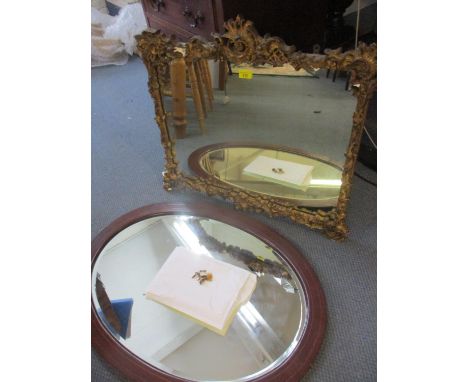 An early 20th century rococo style, gilt plaster wall mirror A/F, together with an oval Edwardian inlaid mahogany wall mirror