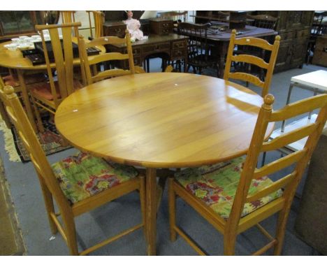 An Ercol pine drop leaf dining table, together with four matching pine Windsor ladder back chairs with a multi coloured Aztec