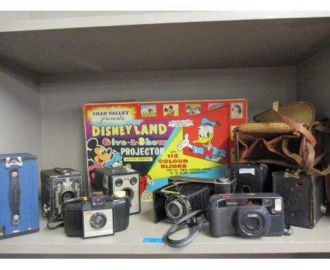 A collection of vintage cameras to include Box Brownies and a Pentax zoom, together with a Chad Valley Disneyland projector s