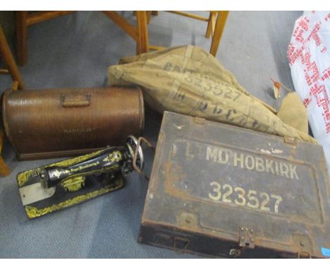 A WWII tin twin handled trunk, together with a military canvas bag and a Singer sewing machine 
