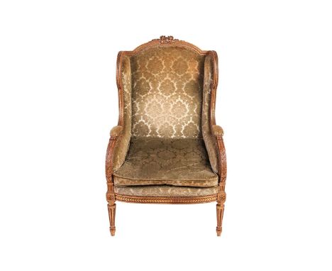 A Louis XVI-style carved wood and gilt gesso Bergere armchair in green stuff over upholstery, with a rose bouquet cresting ov