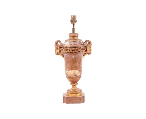 A Louis XVI style rouge marble and ormolu mounted urn table lamp with goat mask handles on a square base with re-entrant corn