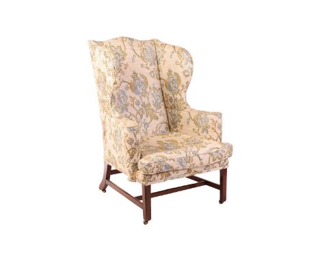 A George III scroll arm wingback fireside chair., with a serpentine top rail, over scroll arms and loose squab cushion, on mo