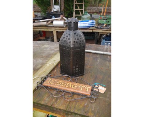 An outdoor lantern and house sign.