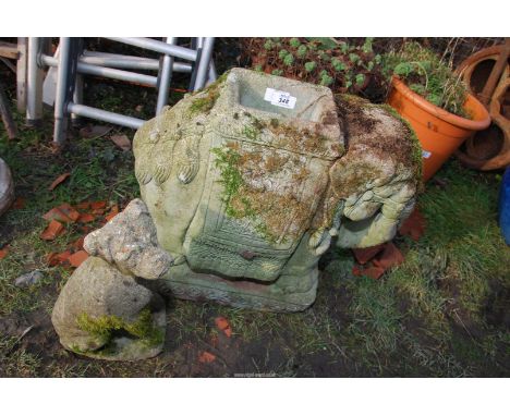 A concrete elephant planter and a dog garden ornament.